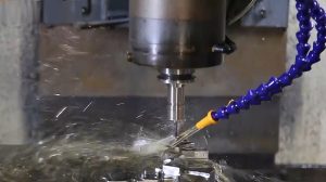 CNC milling operation with coolant on a precision metal part