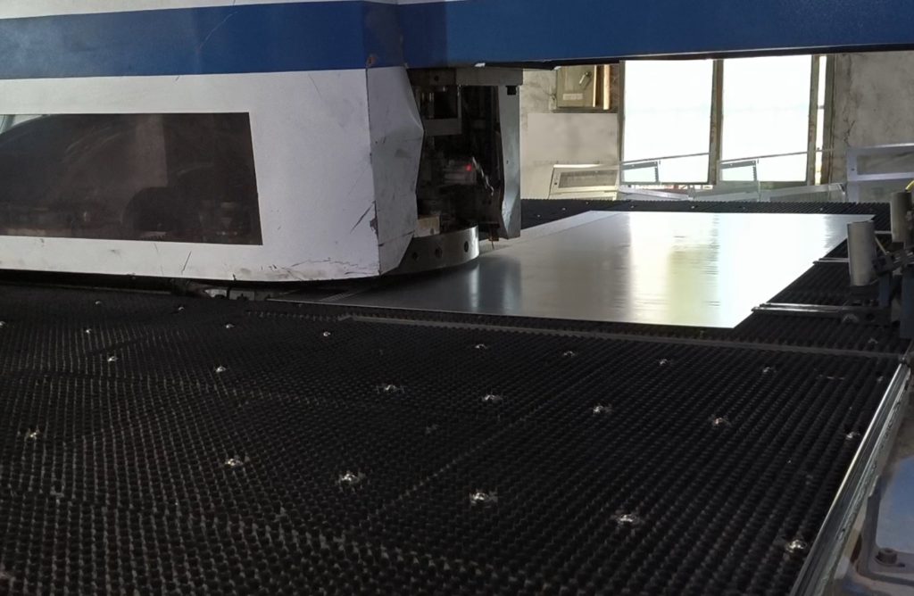 CNC punch press creating hole pattern array in mild steel sheet metal component